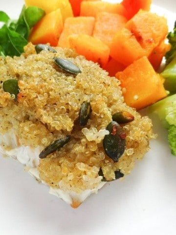 honey quinoa crusted cod on a white plate with broccoli and squash.